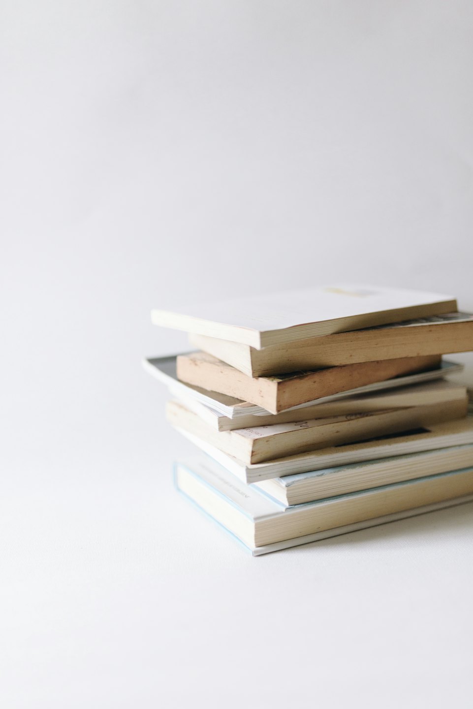 A stack of books on a white surface.