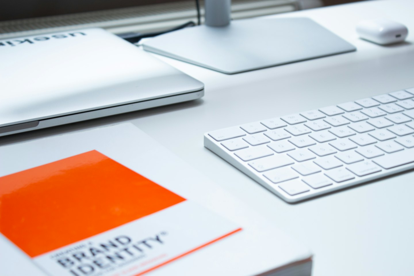 Laptop and book on a modern desk workspace.
