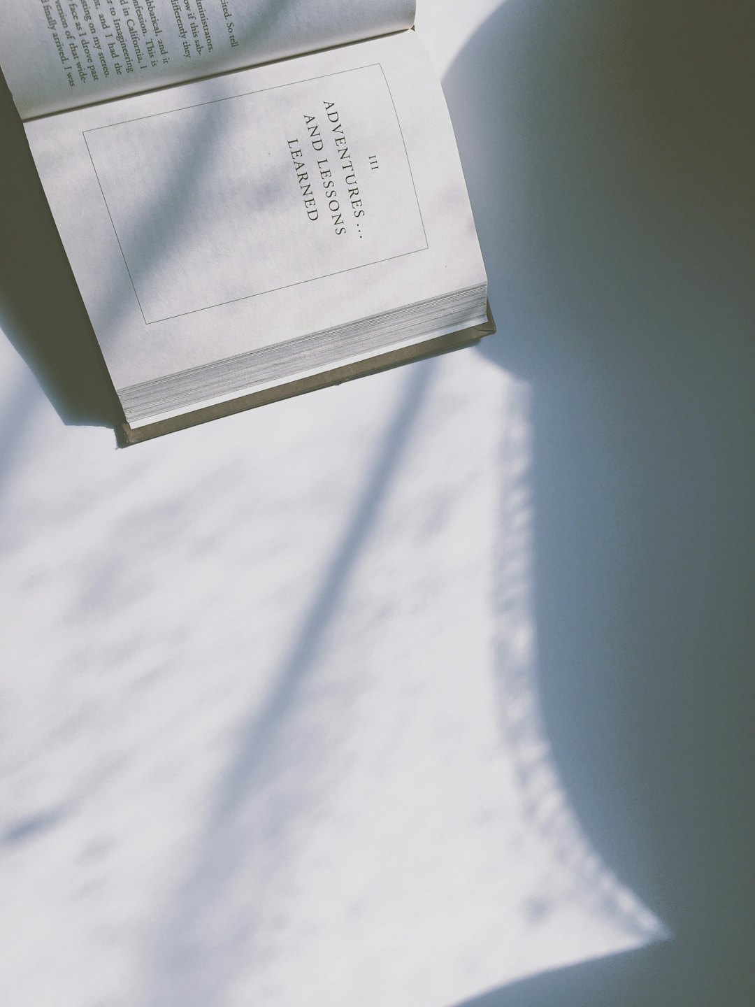 An open book rests on a table with pages displaying text.